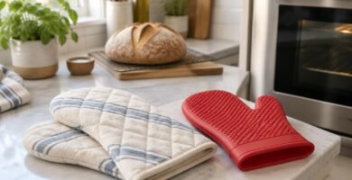 Quilted cotton oven mitts and a silicone oven mitt on a kitchen counter